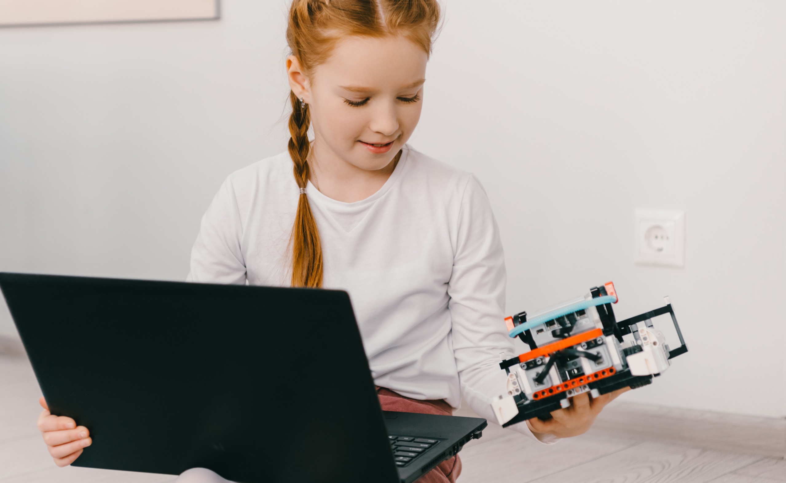 Children building and programming a robot together at an AweSTEM session